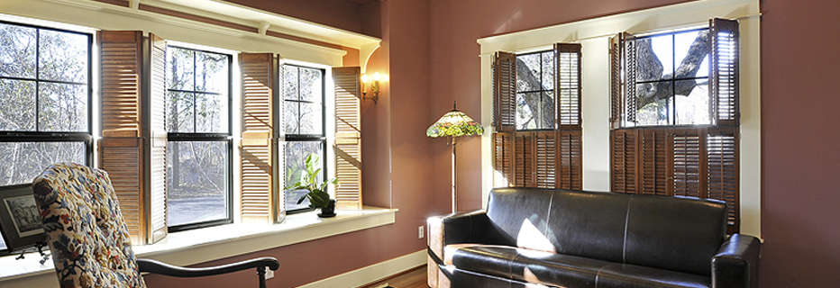 About Ultra*Glaze page showing wide corner of living room space with five shuttered double hung windows allowing sun to shine on fine furnishings